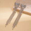 Dettaglio di orecchini a fiocco con nappe argentate e strass scintillanti su pietra - Argento (Perno in argento)