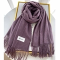 Detailed close-up of soft thick purple scarf featuring fringe ends and a woven label - Deep purple