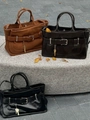 Detailed comparison of leather finishes on city tote bags with buckle accents - Tan