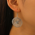 Detailed macro view of silver geometric spiral circular earrings worn by a female model - Silver (White K G-416)