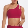 Detail of one-shoulder sports bra with asymmetric straps and wide hem in dark wine red - Carmine