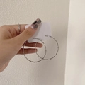 Aros grandes minimalistas de plata sostenidos en la mano sobre un fondo neutro - 4cm / Plateado