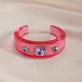 Detailed shot of pink resin cuff bracelet with purple crystals on warm velvet - Rose Red - Light Purple
