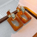 Detail of amber resin rectangle earring with gold metal hoop on a textured fabric surface - Amber (Silver Needle)
