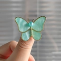 Macro shot of butterfly brooch with green marble resin wings and gold metal edges - Light Green Butterfly