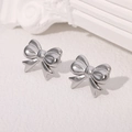 Elegant silver stainless steel bow knot stud earrings on a clean white textured background - Steel