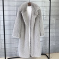 Close-up of light gray faux fur coat with lapel collar hanging on a rack against a wall - S / Gray