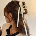 Elegant cream white ribbon bow hair claw clip for women styled in a half-up hairdo - White