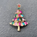 Detailed shot of Christmas tree brooch with multicolored crystals on a golden base - Gold