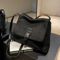 Matzwarte suède crossbodytas met vintage gouden gesp en een zachte rechthoekige vorm - Zwart