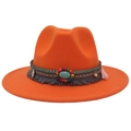 Detailed shot of ethnic embroidery band with turquoise and colorful tassels on orange hat - Orange