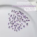 Mix of 100 purple crystal nail art rhinestones in various shapes on a ceramic tray - Approx. 100 Pcs / Crystal Purple