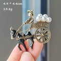 Detail of vintage gold and black brooch showing a figure on a cart with white pearls - Carriage Artificial Pearl