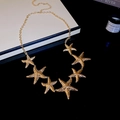 Detail der goldenen Seestern-Halskette mit Metallstruktur und elegantem Ozean-inspiriertem Design - Seestern Taillenkette / Gold