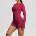 Détail d'un ensemble de yoga magenta sans couture avec haut à manches longues et short taille haute - Carmin