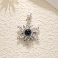 Macro view of silver star necklace pendant with black gemstone and diamond accents - Silver Sun