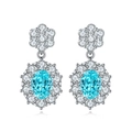 Macro shot of sky blue oval gemstone earrings with sparkling white petal halo and silver plating - Paraiba Blue