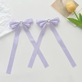 Detailed macro view of lavender ribbon bows with heart rhinestones and long streamers - Purple