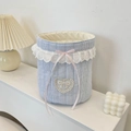 Close-up of quilted blue stripe fabric organizer with lace edge and pink bow detail - Blue Stripes