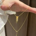 Collana placcata oro con ciondolo a spiga di grano e zirconi tenuta in mano - Collana a Spiga di Grano Placcata Oro / Oro