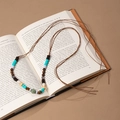 Detail of bohemian handmade beaded belt with tassels on a vintage book backdrop - Multicolor Stone Wood Bead Woven Chain (X451-12)