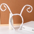 Detailed view of white plush spiral butterfly feelers on a Halloween headband - White Ant Antenna