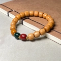 Close-up of sandalwood bamboo-joint lotus bracelet resting on a brown vintage notebook - 8x9mm Three Colors Vintage Beads / New Mountain Sandalwood Color