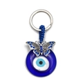 Detail eines blauen Evil Eye Schlüsselanhängers mit Schmetterlings-Charm und Quaste - Schmetterling Design