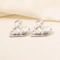 Macro view of heart-shaped earrings with hammered silver texture and 18K plating - Vintage Hammered Heart / Silver