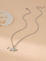 Macro shot of silver shark pendant on Cuban chain with seashell on beige backdrop - Silver