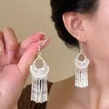 Detail of silver hollowed flower earrings with long tassels on a model for vintage style - 7# Silver Hollow Pattern Tassel Style (Earring Hook)