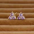 Detailed close-up of clover-shaped gold earrings with three purple zircon gemstones - Gold/Purple Zirconia