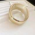 Primer plano de un brazalete ancho de acrílico dorado minimalista con efecto de espejo - Estilo de Onda / Dorado