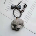 Detailansicht grauer Teddyhund-Schlüsselanhänger mit Glocke und Herzanhänger auf Text - Grauer Teddy-Anhänger