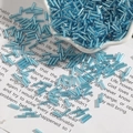 Close-up of 2x7mm blue silver-lined glass bugle beads for DIY jewelry in a decorative bowl - Diameter approx 2mm x Length approx 7mm 15g/Pack Approx 300 Pieces / Lake Blue