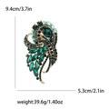 Spilla vintage in lega dorata con cristalli verdi e dimensioni 9,4x5,3cm visualizzate - Verde