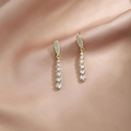 Elegant gold drop earrings featuring white zircon inlay and pearls on champagne silk fabric - Gold Long Teardrop Rhinestone