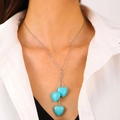 Bohemian silver necklace featuring three heart-shaped turquoise stone pendants on a model - Triple Heart Tassel Style (10246)