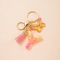 Detail of pink resin letter Y keychain with gold sequins, butterfly charm and tassel - Letter Y