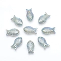 Macro detail of nine iridescent fish-shaped glass beads for DIY jewelry making - Transparent Green