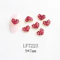 Vue détaillée de strass cœur rouges pour nail art avec sertissage doré, 9x7mm - Cœur doré strass rouge (LF7223)
