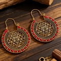 Detailed view of bohemian Sri Yantra earrings with red beads on dark wood background - 09 Antique Gold 3651