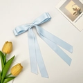 Detail of light blue satin double bow hair clip with long ribbons on white background - Blue