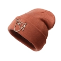 Detail view of orange knit beanie featuring silver metal cross and butterfly charms - One Size / Rust