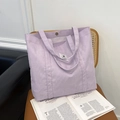 Lavender purple corduroy tote bag with magnetic closure and woven label on wooden chair - Light Purple