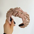 Detail of pink satin knotted headband with sparkling rhinestones in gold settings - Pink