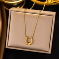 Elegant gold U-shaped horseshoe pendant necklace on a beige jewelry display box - U Shape / Gold
