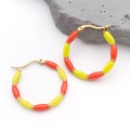 Vue détaillée des boucles d'oreilles créoles dorées avec perles en émail jaune et orange - 31x31MM / Orange