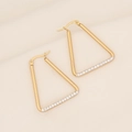 Detalle macro de pendientes triangulares bañados en oro de 18K con circonitas brillantes - Triángulo