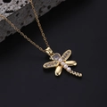 Golden dragonfly necklace with white pearls and heart-shaped gemstone on black stone background - Style P-Gold Pearl Heart Gemstone